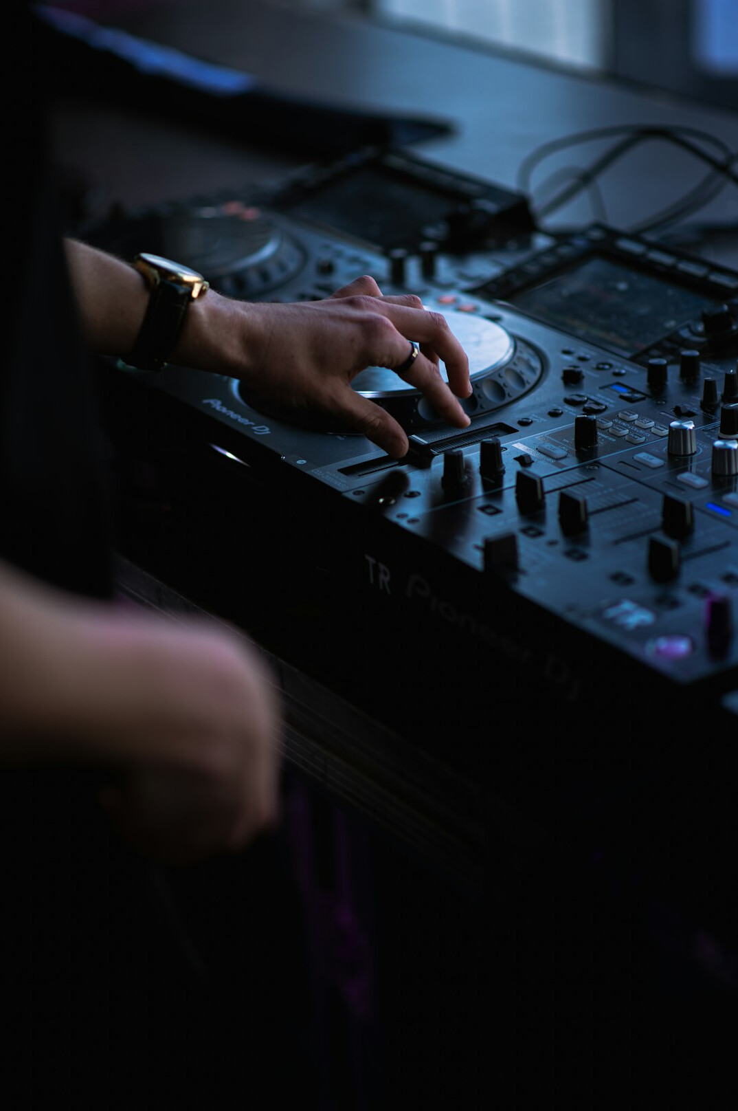 Close-up of hands adjusting faders on an audio mixing console