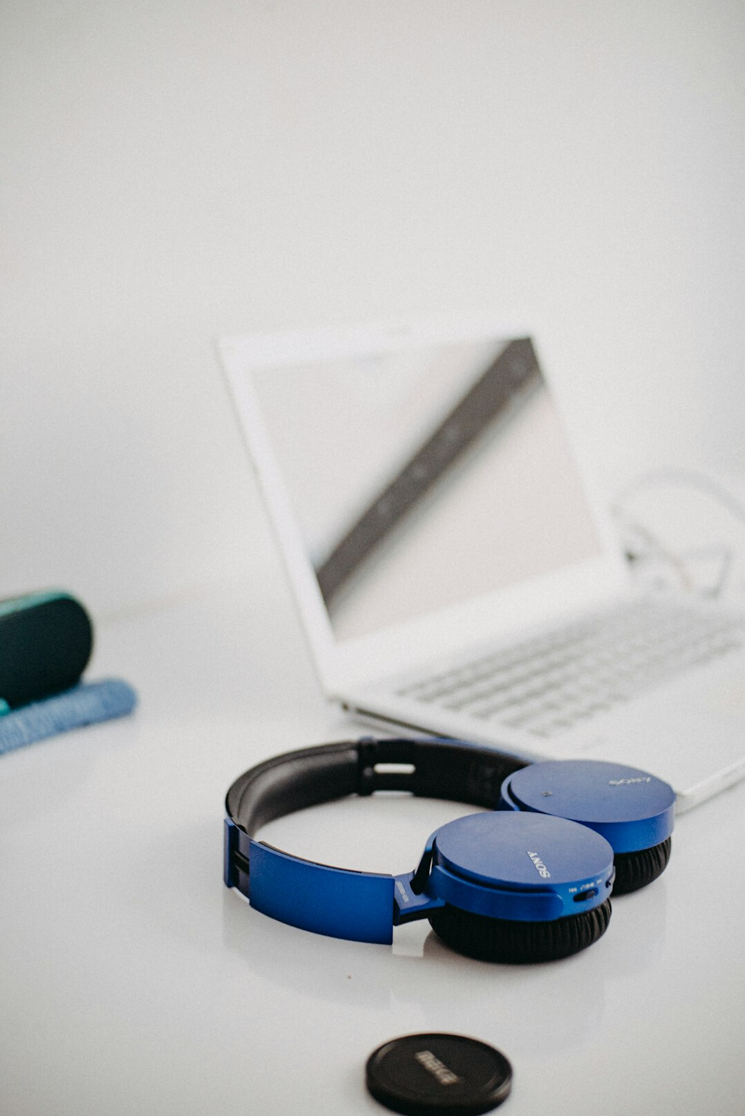 Laptop on a desk showing audio editing software with headphones